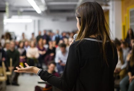 Woman speaking in front of crowd at an event
