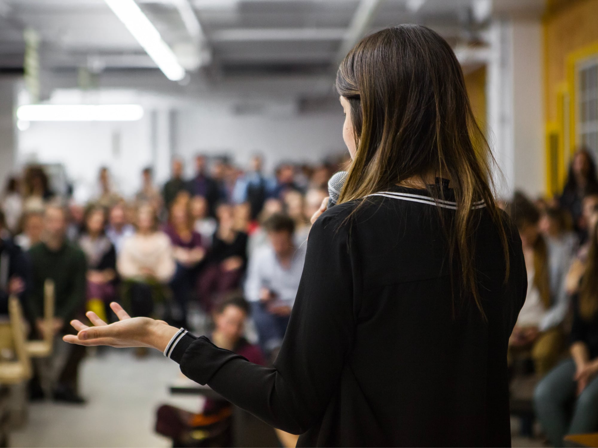 Woman speaking in front of crowd at an event