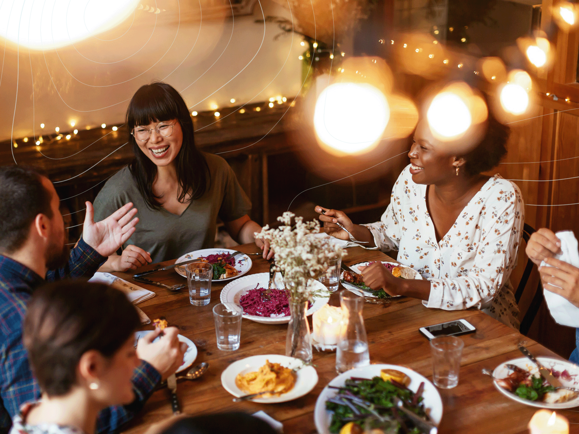 A diverse group of people smiling and enjoying a meal together